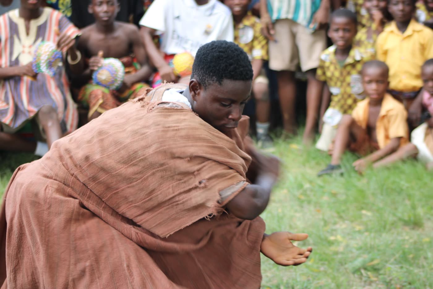 An elder dancing as the community looks on