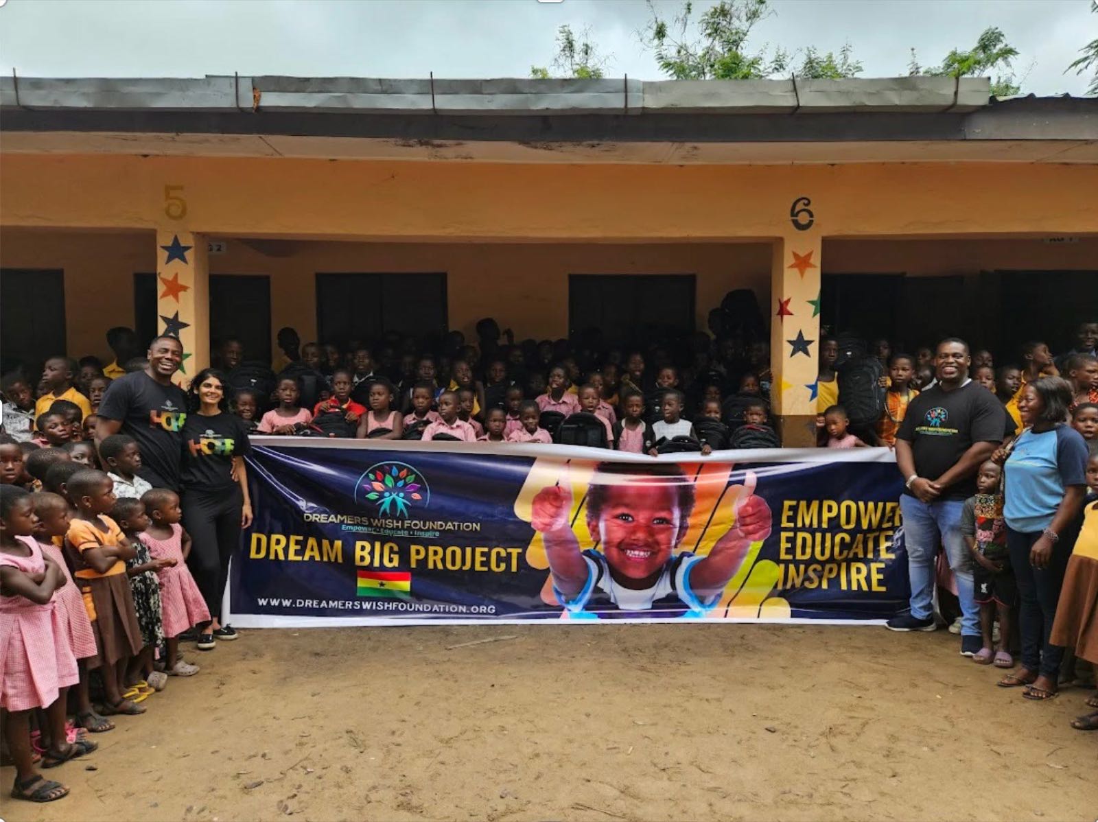 Godwill Tandoh, volunteers and students in Ghana with the Dreamers Wish Foundation Dream Big Project banner in front of their school