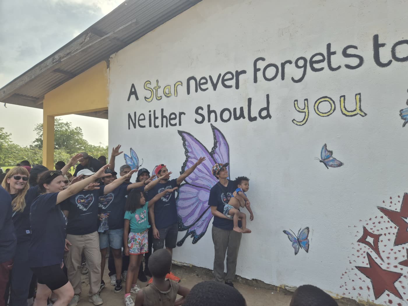 Students and volunteers celebrating at a finished mural