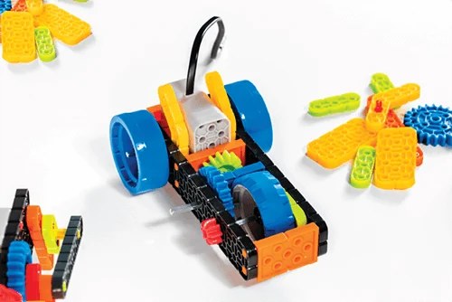 A colorful VEX GO gear build with blue wheels and loose pieces ready to snap together
