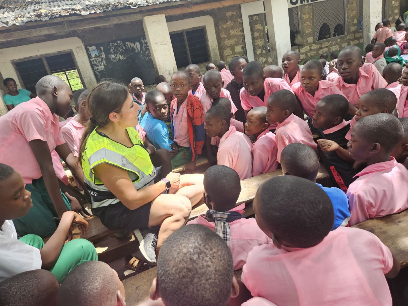 A volunteer leads a classroom workshop surrounded by dozens of students at Mijomboni Primary School in Kenya